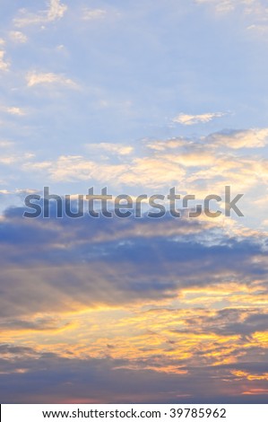 Blue sky at sunset with sunbeams and bright clouds
