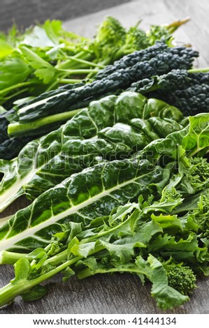 Dark green leafy fresh vegetables on cutting board