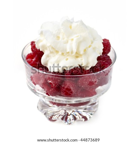 Fresh red raspberries with whipped cream in glass bowl isolated on white