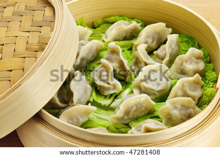Closeup of bamboo steamer with cooked dumplings