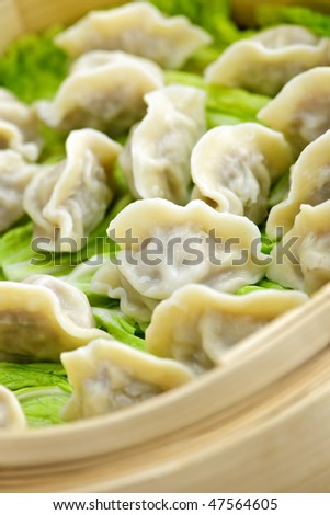 Closeup of bamboo steamer with cooked dumplings