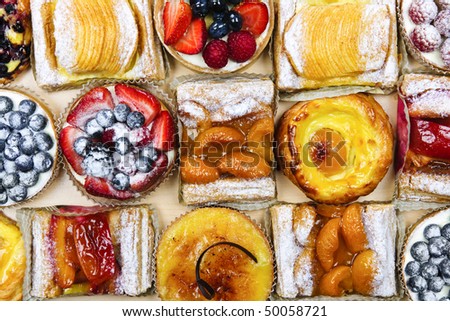 Background of assorted fresh sweet tarts and pastries from above