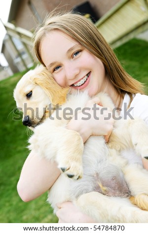  photo Portrait of smiling teenage girl holding golden retriever puppy