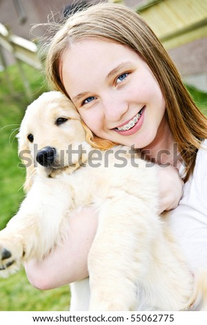  photo Portrait of smiling teenage girl holding golden retriever puppy