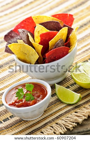 Bowl of salsa with colorful tortilla chips and lime