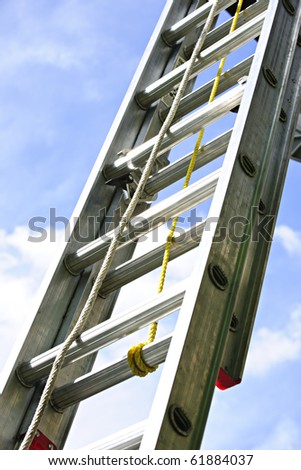 Closeup of construction aluminum extension ladder against blue sky