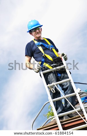 Construction worker standing on roof near ladder