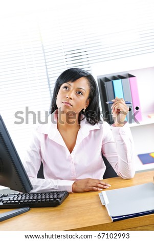 Young black business woman thinking at desk in office