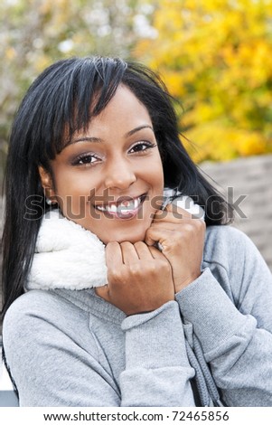 Portrait of happy smiling young black woman outside in the fall