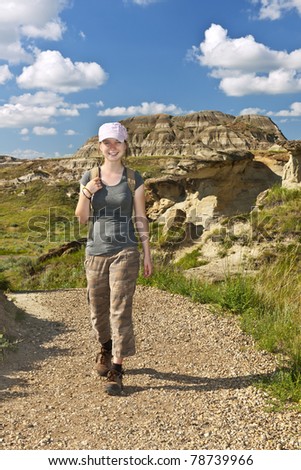 Smiling girl walking on path at the Badlands in Dinosaur provincial park, Alberta, Canada