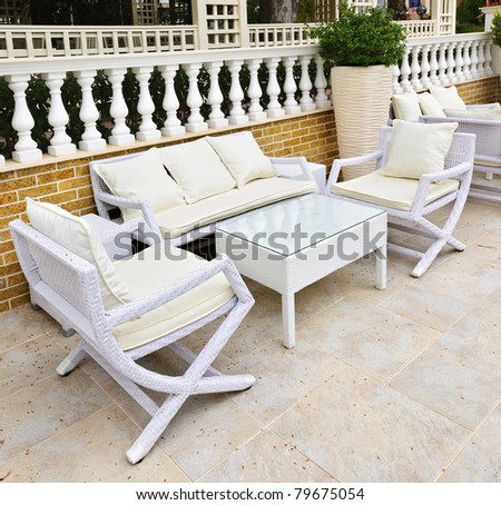 Wicker patio furniture outdoor in area paved with natural stone