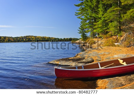 Red canoe on rocky shore of Lake of Two Rivers, Ontario, Canada