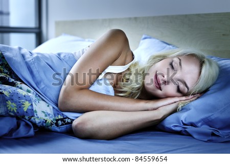 Young woman sleeping peacefully at night in bed