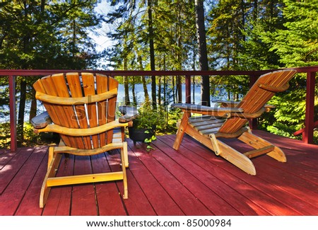 Wooden deck at forest cottage with Adirondack chairs
