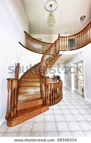 Curved oak staircase in luxury home entrance hall