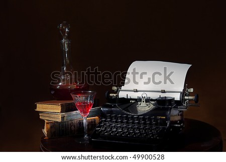 still life with antique typewriter wine carafe and old books