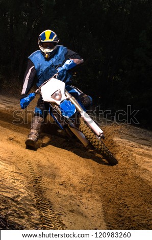 Enduro bike rider on action. Turn on sand terrain.