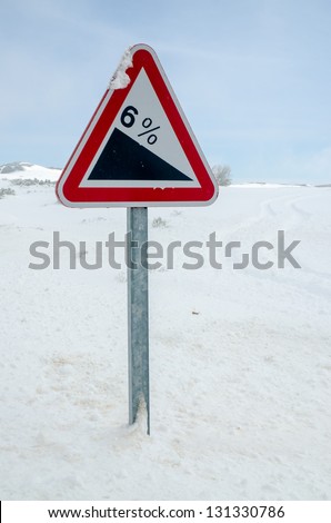 Steep hill warning signpost in a Snowy Road.