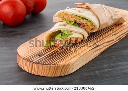 Tortillas with chicken and vegetables, on chalk board table.