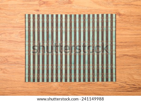 Bamboo place mat on wooden deck table.