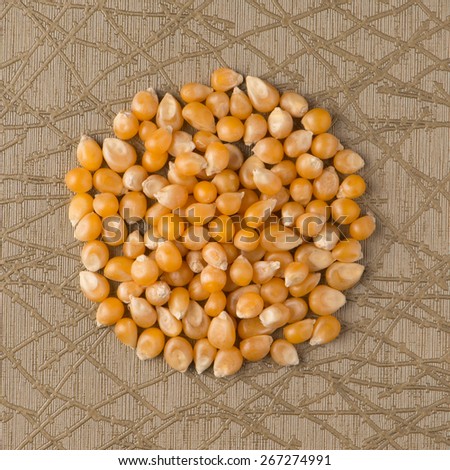 Top view of circle of corn against green vinyl background.