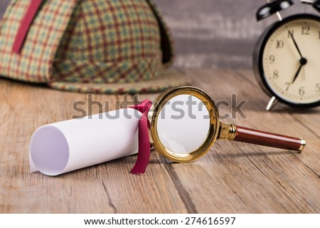Wrapped paper sheets and magnifying glass on Old Wooden table.