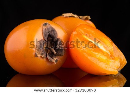 Persimmon fruits on black background.