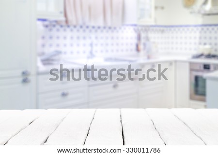 Wooden textured table over blurred kitchen interior background