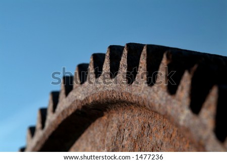 rusty gear with big teeth against clear blue sky, shallow DoF