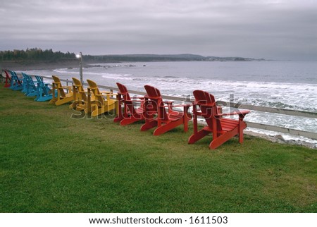 stormy weather at the beach with adirondack chairs facing rough seas