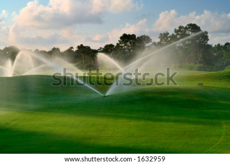 manicured florida golf course gets irrigated in morning