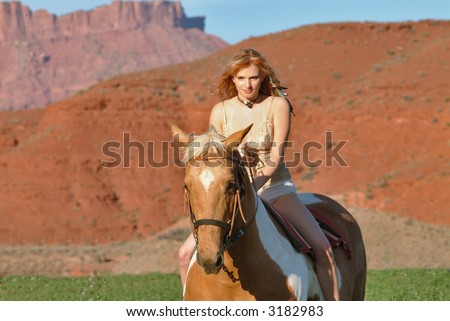 attractive young female rides horseback at dude ranch in southwest usa red rock region