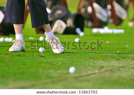 senior golfer practices at the driving range