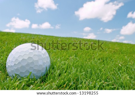 golf ball on grass bunker with blue sky background