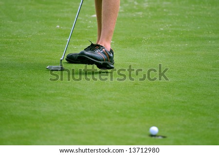nice golf putt (focus on golfer)