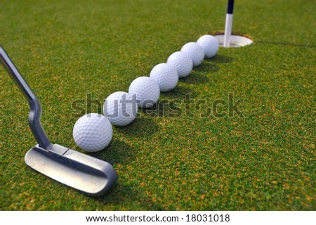 putting golf balls in line to cup
