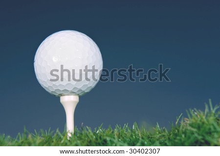 golf ball on tee against dark blue background
