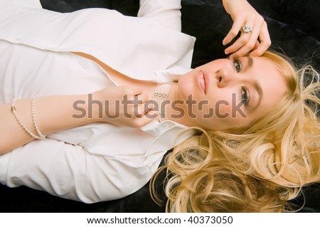 lovely blond female models with her diamonds and pearls while reclining
