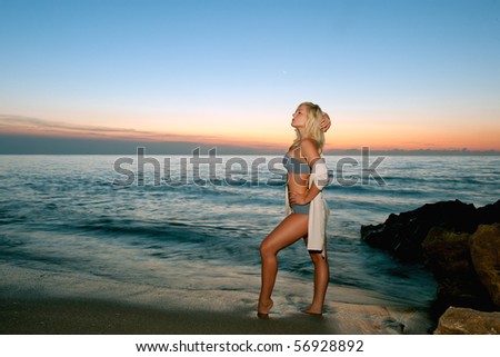 lovely blonde bikini model by atlantic ocean at sunrise, long exposure with fill flash