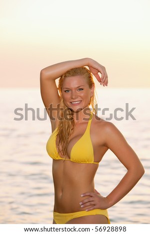 lovely blonde bikini model by atlantic ocean at sunrise