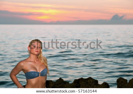 lovely blonde bikini model by atlantic ocean at sunrise