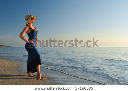 lovely blonde fashion model by atlantic ocean in morning with clear blue sky background