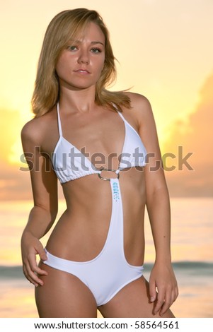 lovely female swimsuit model at atlantic ocean during dramatic sunrise