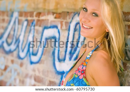 lovely natural blonde female in bikini against graffiti wall