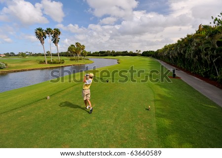 golfer teeing off on beautiful florida course