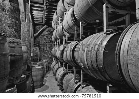 old underground wine storage cave with racks of wooden barrels
