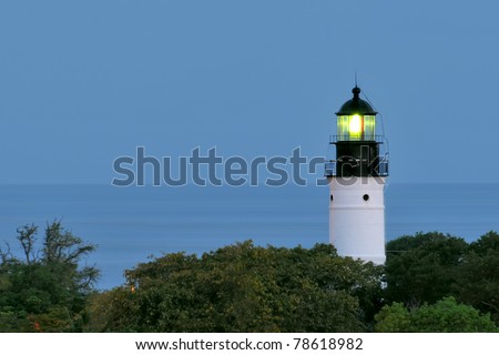 historic key west, florida, lighthouse beaming on clear night with ocean in background