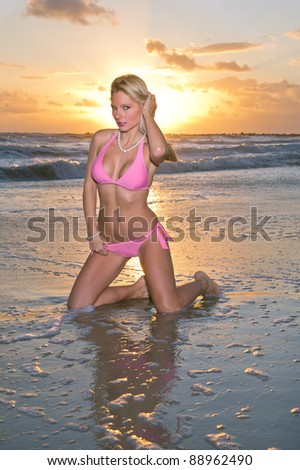 lovely blond bikini model against dramatic florida sunrise over atlantic ocean