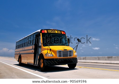 school bus traveling on florida\'s overseas highway from low angle against blue sky