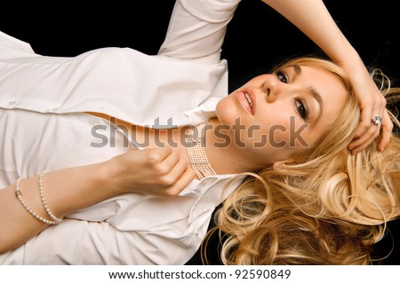 lovely blonde female model with pearl and diamond jewelry against dark background